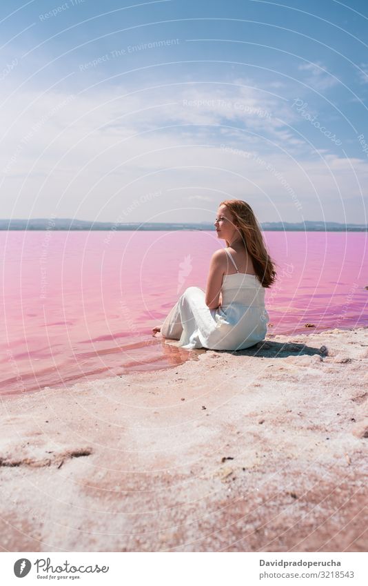 niedlichen Teenager Frau trägt weißes Kleid sitzt auf einer erstaunlichen rosa See jung Kochsalzlösung romantisch Tourismus Sommer Sommersprossen Glück allein