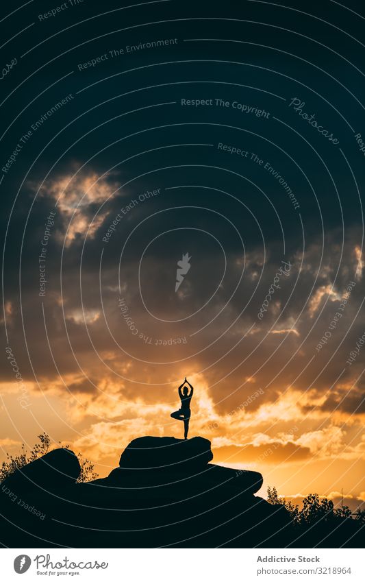 Silhouette einer Frau, die Yoga-Posen im Freien bei einem erstaunlichen Sonnenuntergang einnimmt Aktivität allein Asana Gleichgewicht schön brünett Damm