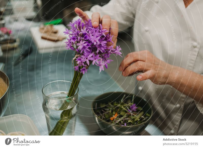 Frau bereitet Salat von Hand am gedeckten Tisch zu Gemüse grün Küchenchef Speise Lebensmittel frisch Abendessen rot Feinschmecker selbstgemacht Restaurant