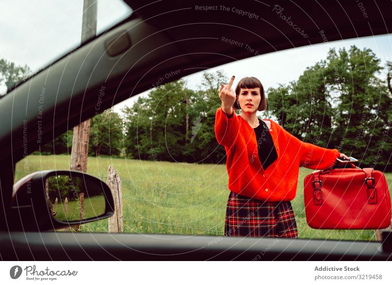 Frau im roten Pullover gestikuliert in der Nähe eines Autos auf der Straße automatischer Stopp Koffer gestikulierend PKW reisen stylisch Gepäck Natur schön
