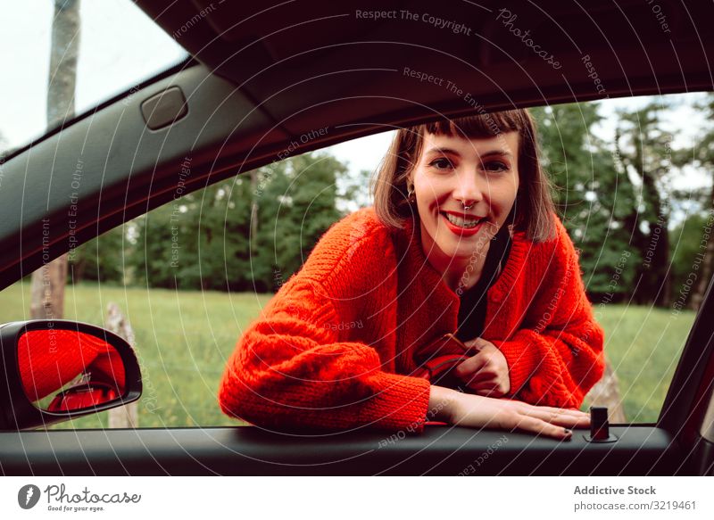 Frau stellt Koffer ins Autofenster rot PKW Straße reisen stylisch Gepäck Natur schön Tasche Mode Warten Freiheit allein Lächeln Ausflug Reise modern Fahrzeug