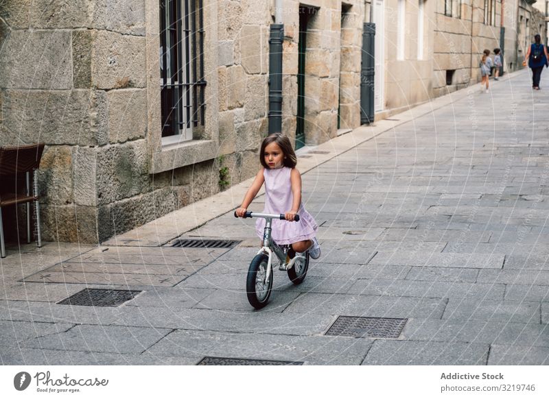 Mädchen auf dem Fahrrad in enger Straße Lächeln Sommer Glück Spaß Sport Großstadt heiter Tag aktiv Kindheit urban Radfahrer Reiten Feiertag Lifestyle freudig