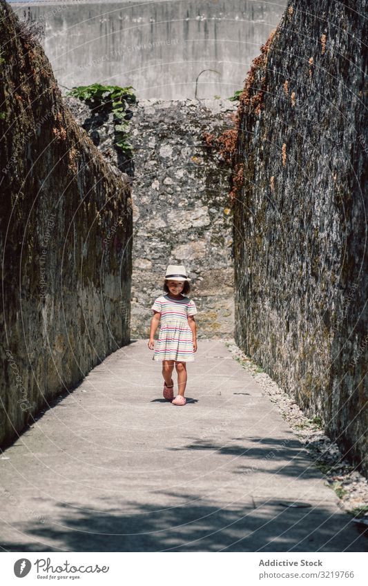 Mädchen in schmalem Steingang Abenteuer Glück laufen Sonnenlicht Wand reisen Tourist Natur Sommer Feiertag Kind Architektur Gebäude Ausflugsziel alt Außenseite