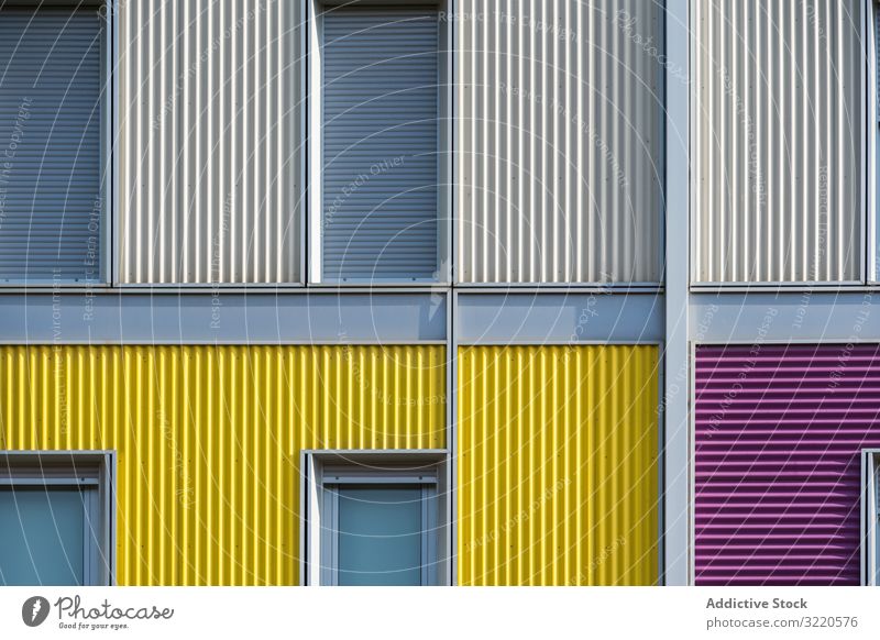 Fassade eines modernen mehrfarbigen Gebäudes mit schmalen Fenstern Außenseite farbenfroh Architektur Haus Anwesen Konstruktion Investition wohnbedingt Struktur