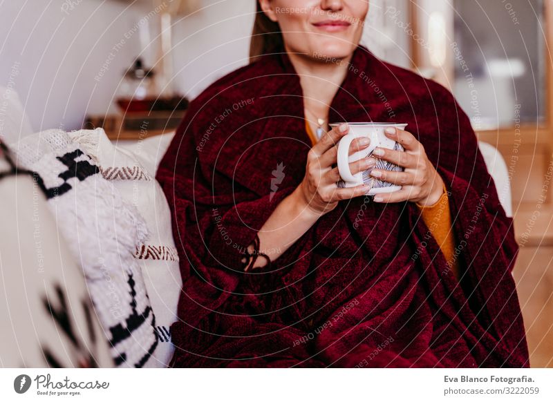 Schöne Frau auf dem Sofa sitzend, eine Tasse Tee genießend. Lebensstil im Haus, Herbstsaison Kaffee heimwärts Morgen Kaukasier Lifestyle Innenaufnahme Frühstück