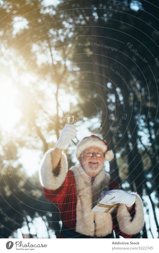 Weihnachtsmann mit Geschenk und Glocke Mann Klingel Feiertag Weihnachten präsentieren Veranstaltung Senior männlich besinnlich nachdenklich ernst bärtig