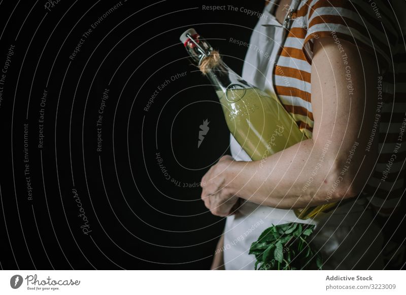 Weiblich mit Flasche Holunderblütensirup Frau Sirup Glas selbstgemacht Getränk trinken Erfrischung lässig ernst gestreift T-Shirt Schürze stehen Frucht