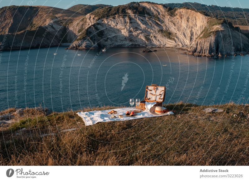 Picknickmatte mit romantischer Kulisse in der Nähe von Meer und Bergen Seeküste Strand Sommer Freizeit Himmel MEER sich[Akk] entspannen Glas trinken Urlaub