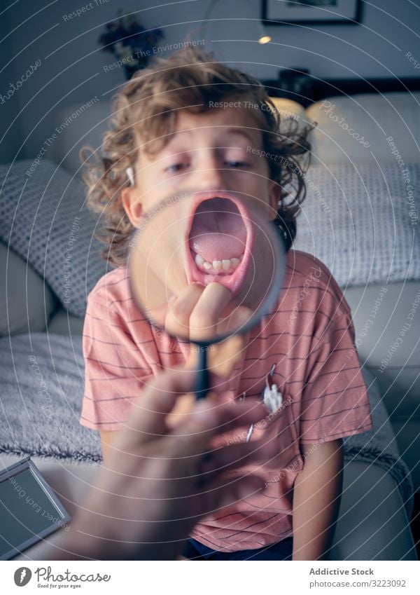 Kind untersucht Milchzahn unter der Lupe Zahn Lächeln Kindheit mündlich melken Mund dental offen Gesicht zeigend Ausdruck heiter Punkt kieferorthopädisch