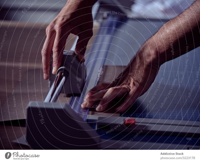 Professioneller Buchmacher schneidet Papier mit präziser Ausrüstung Trimmer Hand professionell Kutter rollierend Gerät Werkzeug Kunsthandwerker messen