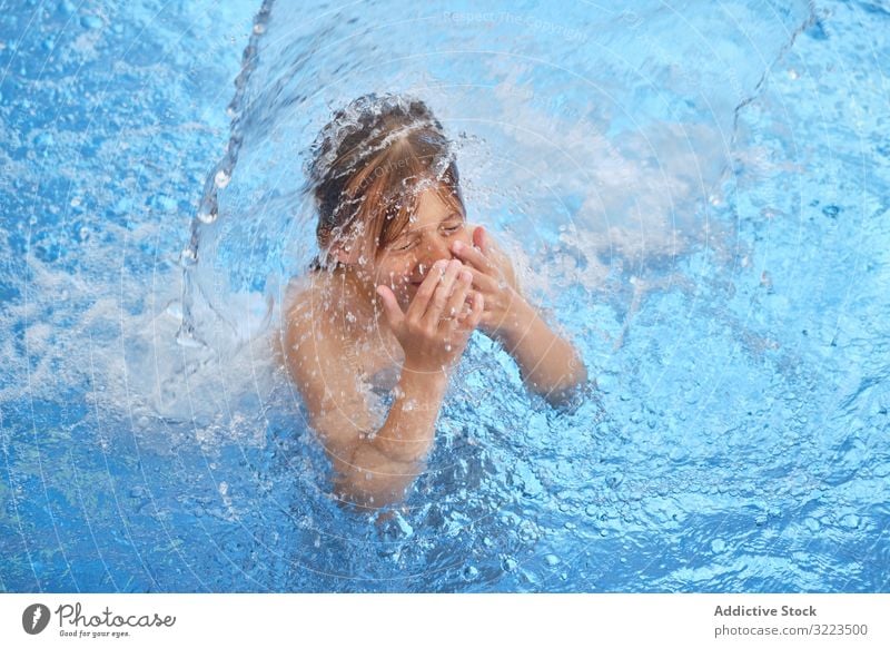 Junge im Schwimmbad mit blauem Wasser jung schwimmen Kind Schwimmer nach Luft schnappen geschlossene Augen offener Mund Wasserfall Wasserpark Aktivität Spaß