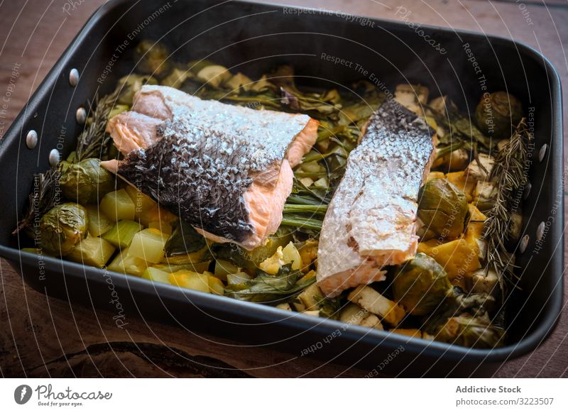 Hausgemachtes gesundes gebackenes Gemüse mit rotem Fisch Lachs Spielfigur Lebensmittel Haut Garnierung Bratpfanne groß Suppengrün gekocht vorbereitet Omega