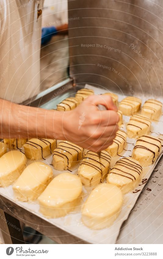 Getreidekonditor, der Gebäck mit Schokoladencreme dekoriert Konditor Bäckerei Dekor drücken Glasur frisch Qualität Vorbereitung Kleinunternehmen Lebensmittel