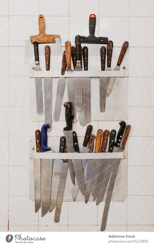 Kochwerkzeuge an der Wand hängend Werkzeug Küche Bäckerei Klammer Kulisse Messer Spachtel professionell Sammlung beigefügt gekachelt Vorbereitung Gerät