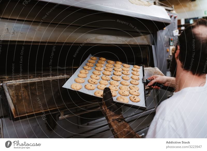 Kahlköpfiger Bäcker prüft Gebäck im Ofen Mann Bäckerei schauen Sie Arbeit Konditor prüfen Koch heiß Prozess männlich Erwachsener Uniform Küche Kleinunternehmen