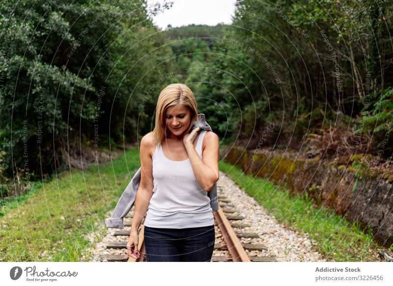 Frau geht entlang der Eisenbahn durch einen grünen Teil der Straße extrem laufen Wald reisen Reise Hain Verkehr Passagier Ausflug klug Tourismus Stahl Natur