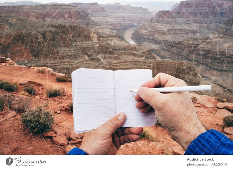 Männliche Zeichnung im Notizbuch am Felsen Mann Schlucht Klippe Saum Hinweis zeichnen Notebook Tagebuch ruhen männlich USA Natur reisen Landschaft Wanderer