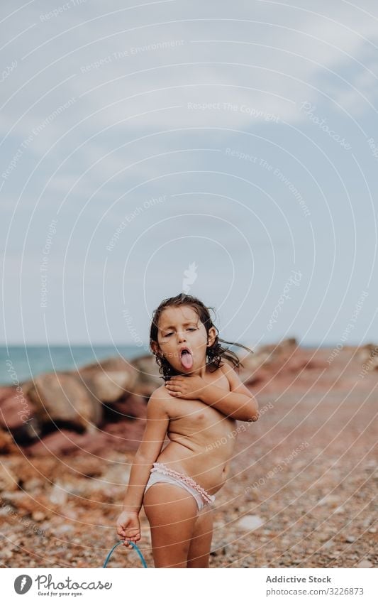 Lächelndes Mädchen spielt an felsigem Strand spielen Sommer Gießkanne Urlaub laufen Kind Feiertag Spaß MEER Spielen Meer Person aktiv Aktivität Uferlinie wenig