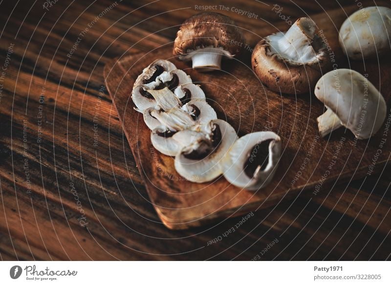 Champignons auf einem Schneidebrett aus Holz Lebensmittel Pilz Ernährung Bioprodukte Vegetarische Ernährung frisch lecker braun genießen Foodfotografie