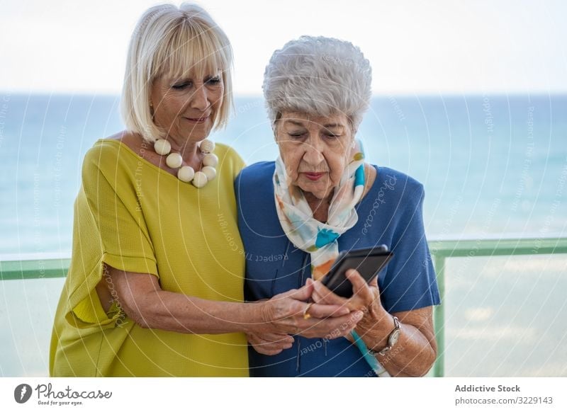Ältere Damen mit Smartphone auf dem Hotelbalkon Frauen benutzend älter Freund Balkon MEER Resort soziale Netzwerke Senior reif Zusammensein Freundschaft Gerät