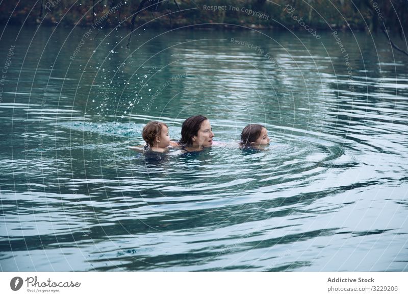 Mutter mit Kindern schwimmt im See im Heilbad schwimmen Spa Familie warm Resort Aktivität platschen Frau Geschwisterkind Zusammensein Freizeit Lifestyle