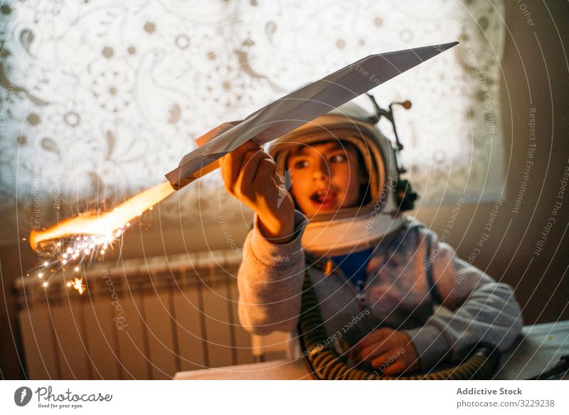Verträumtes Kind hat Spaß mit Spielzeugflugzeug Junge spielen phantasieren Ebene Papier Flugzeug verträumt Astronaut Schutzhelm heimwärts Glück Kindheit
