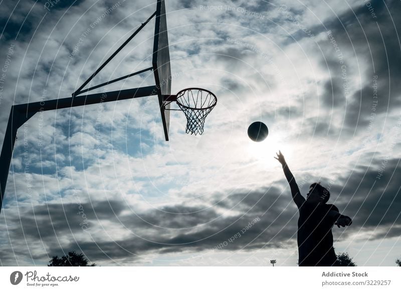 Junger Mann spielt auf einem Basketballplatz im Freien. Athlet Konkurrenz Sportgerät Erwachsener Erholung Aktion Ball Porträt aktiv Aktivität Asphalt Großstadt