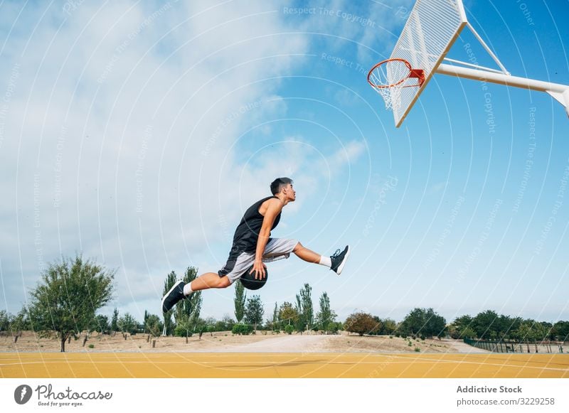 Junger Mann spielt auf einem Basketballplatz im Freien. Athlet Konkurrenz Sportgerät Erwachsener Erholung Aktion Ball Porträt aktiv Aktivität Asphalt sportlich
