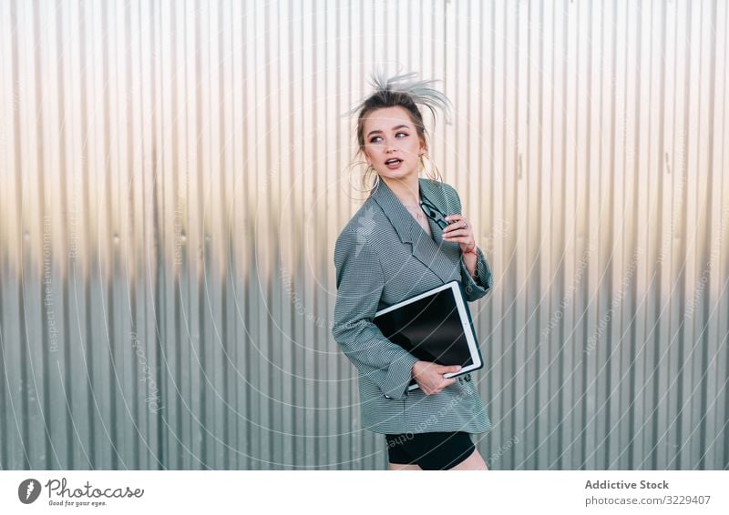 Frau mit Tablette im schicken Anzug steht neben der Wand und hält eine Sonnenbrille Geschäftsfrau arbeiten benutzend stylisch trendy Business Mitteilung Manager