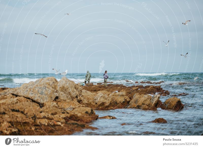 Zwei Mann fischen an der Meeresküste Lifestyle Angeln Ferien & Urlaub & Reisen Sommer Strand Mensch maskulin Erwachsene 2 Umwelt Küste Portugal fangen genießen