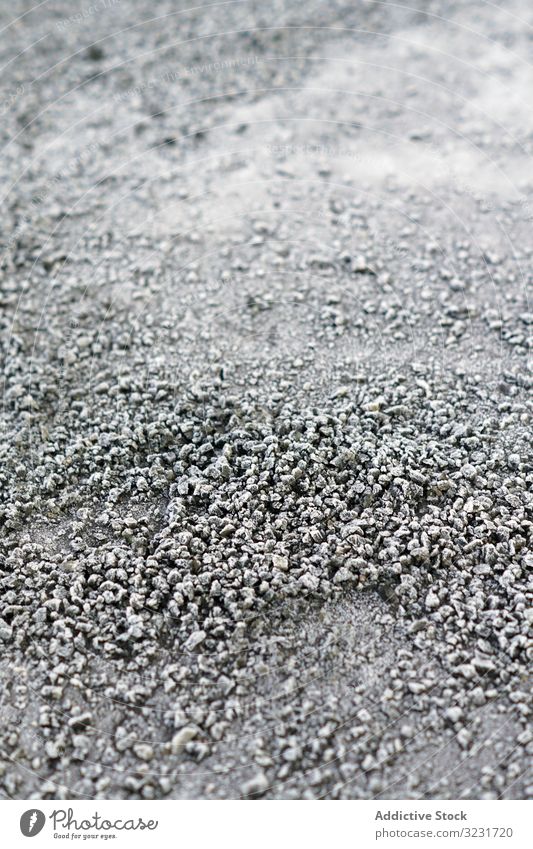Ein Haufen gefrosteter Kieselsteine auf dem Boden Frost Textur klein gefroren Felsen grau eisig Schnee natürlich abstrakt Kopfsteinpflaster dunkel Felsbrocken
