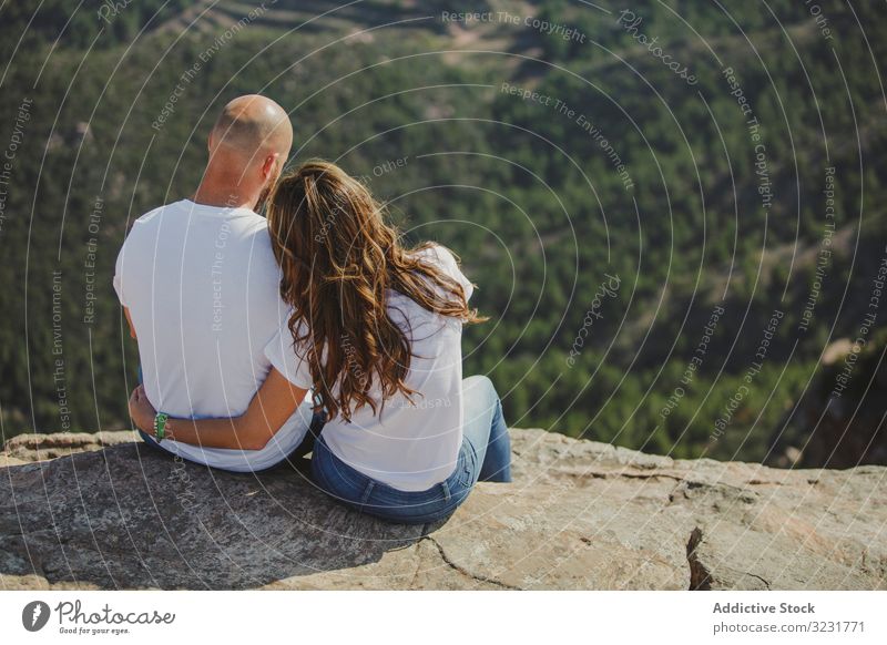 Glückliches Paar am Bergfelsen sitzend Berge u. Gebirge Freiheit Klippe romantisch entspannt genießend Saum Höhe übereinstimmend identisch jung Erwachsener
