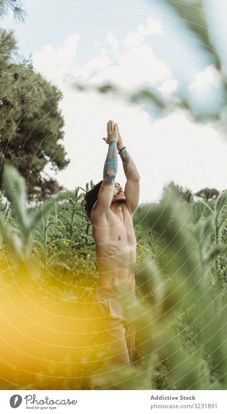 Mann trainiert auf der Wiese meditierend Mediation Konzentration sich[Akk] entspannen Zen Yoga Meditation Gelassenheit fokussiert Wellness ruhig friedlich