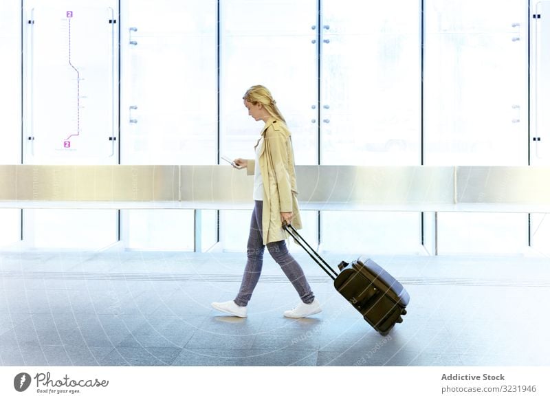 Reisende Frau mit Gepäck zu Fuß im Flughafen Smartphone Tourismus Passagier Gerät Mobile Apparatur Koffer benutzend Terminal Internet Ebene online reisen
