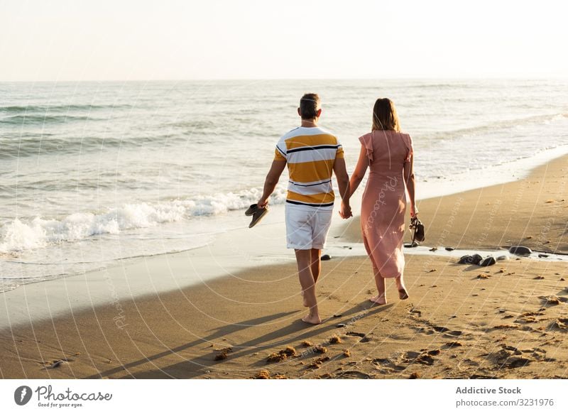Erwachsenes Paar auf dem Weg zum Meer MEER Strand Spaziergang Sand winken Resort Zusammensein Händchenhalten Urlaub Mann Frau Erwachsener Barfuß Flitterwochen