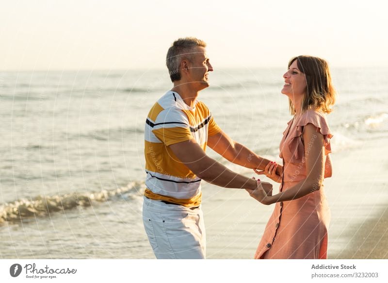 Erwachsenes Paar tanzt am Meer Strand Resort Liebe MEER Tanzen spinnen Lächeln Glück Urlaub winken Wasser Mann Frau Spaß Erwachsener Flitterwochen Sommer Ufer