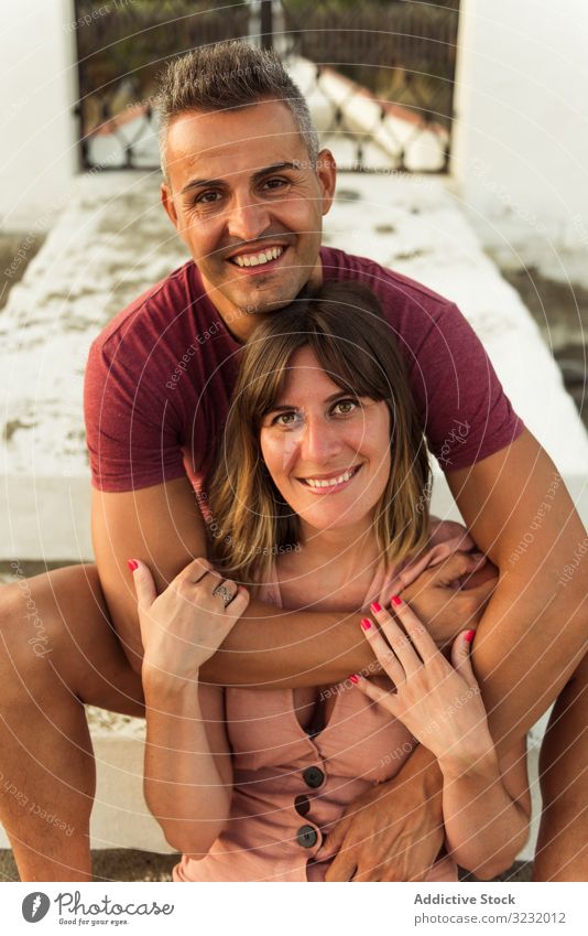 Erwachsenes Paar umarmt sich auf Stufen Liebe Umarmung Freitreppe sitzen Lächeln Erwachsener Gebäude Partnerschaft Glück Mann Frau Zusammensein Lifestyle