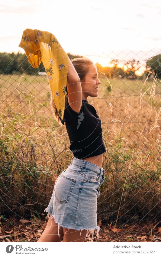 Glückliches Weibchen im Sommer auf der Wiese Frau Feld Inhalt lässig Hemd romantisch Abheben brüniert Zaun Metall Kettenglied Natur Landschaft Schönheit