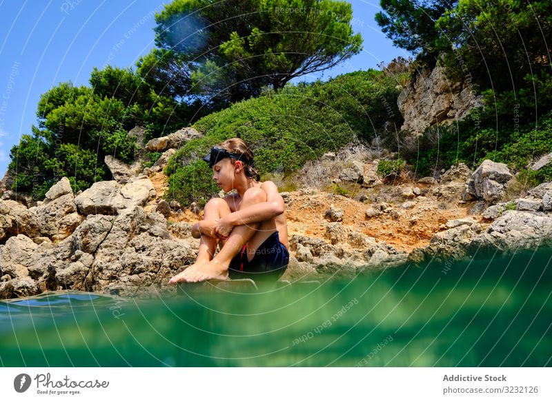 Kleiner Junge macht sich bereit, ins Wasser zu springen MEER Sinkflug Sommer Meeresufer Gleichgewicht Kind Mundschutz Küste reisen aktiv felsig Tourismus Klippe