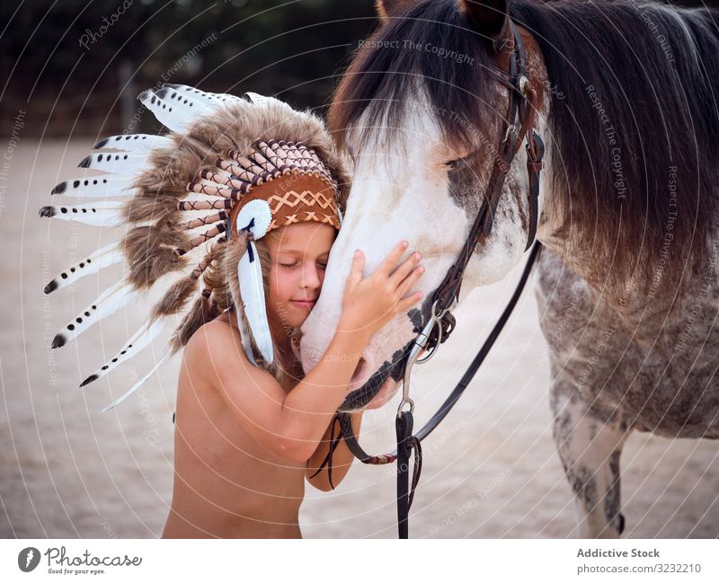 Zarter Junge umarmt Pferd auf dem Bauernhof Bonden Kind Angebot authentisch Harmonie Kriegsmütze Art Hengst Inder Liebe berühren Tracht Streicheln konzentriert