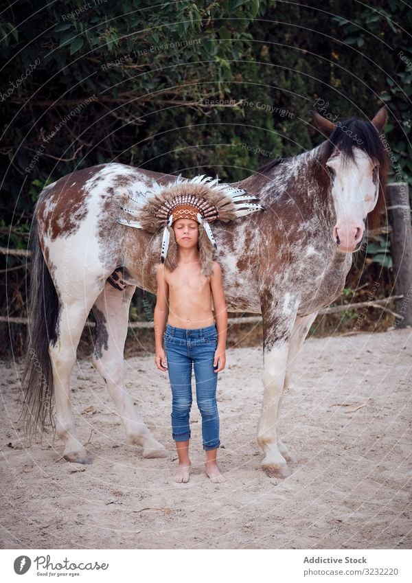 Nachdenkliches Kind umarmt Pferd Junge Umarmen Harmonie Kriegsmütze authentisch Inder Pferderücken Liebe Art Bonden Bauernhof Tracht Wachtraum Meditation