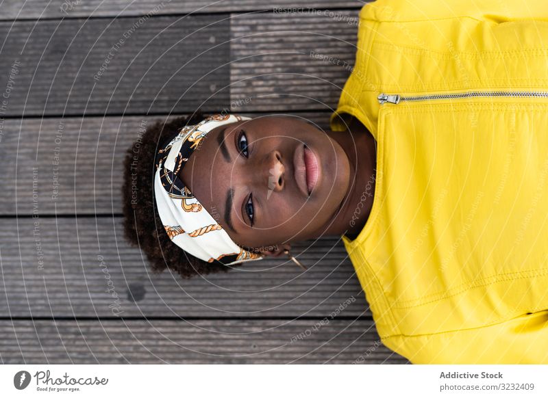 Kluge Frau chillt auf dem Fußweg stylisch Kälte sich[Akk] entspannen modern klug Stock hölzern Jacke Afroamerikaner jung cool trendy Glück Zeitgenosse