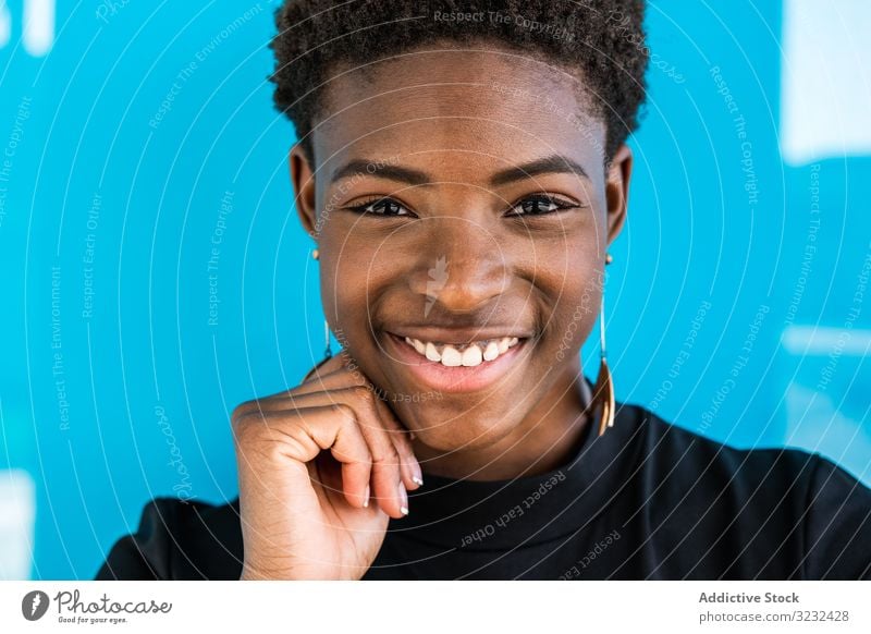 Schwarze Frau auf blauem Hintergrund stehend cool Inhalt Afroamerikaner Glück Sommer heiter Lächeln Schönheit Stil Feiertag jung Straße attraktiv Freude