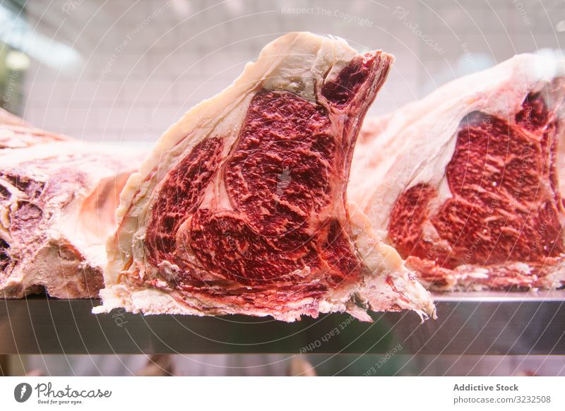 Rohes Fleisch auf der Kühlanlage einer Metzgerei zur Reifung T-Bone-Steak madure Lende gealtert geschnitten frisch Beefsteak ungekocht Protein Kuh Filet