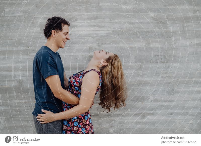 Mann und Frau umarmen sich an der nahe gelegenen Straßenmauer Paar Spaß heiter aufgeregt spielerisch Wand Menschen verrückt gelungen Inhalt freudig Triumph