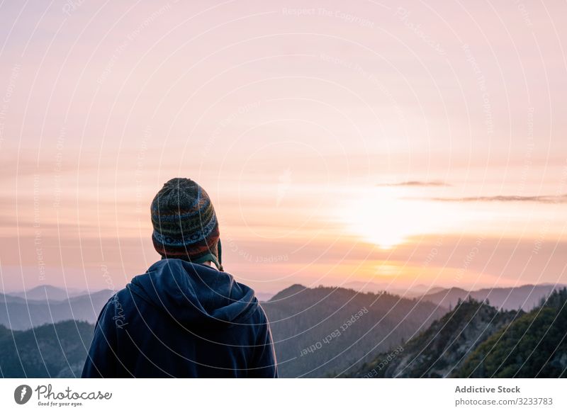 Warm gekleidete Person, die den Sonnenaufgang im Berg betrachtet Tourist Berge u. Gebirge reisen Natur Landschaft Sonnenuntergang Abenteuer Tourismus Felsen