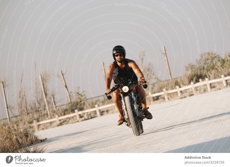 Selbstbewusstes männliches Motorradfahren Mann Schutzhelm moto Laufwerk Sonnenbrille erfreut selbstbewusst sitzen Feld Verkehr Straße Fahrrad Biker Freiheit