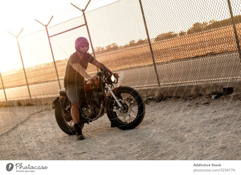 Starker Mann fährt Motorrad Laufwerk Straße moto Sonnenbrille ernst stark männlich Vollbart Mitfahrgelegenheit Menschenleer Verkehr Fahrrad Biker Freiheit