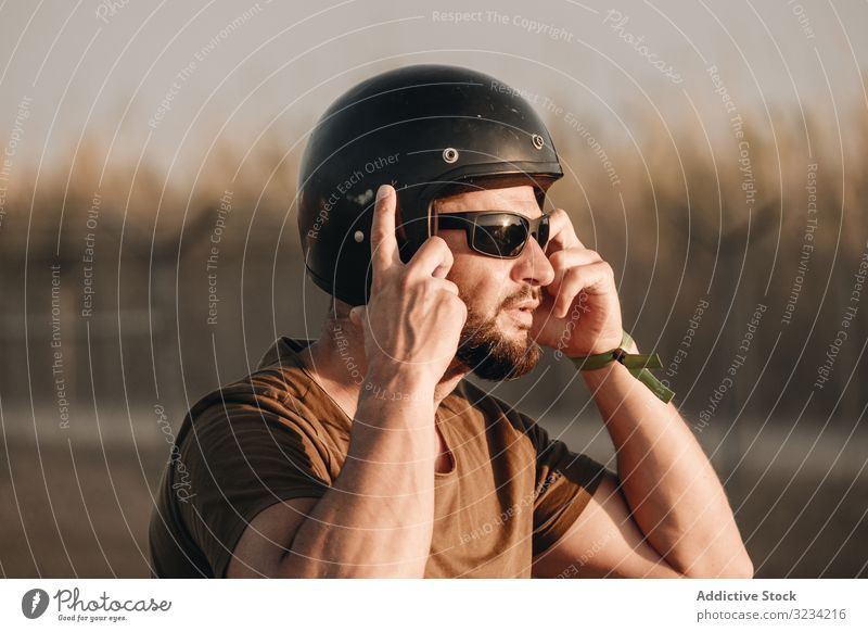 Nachdenklicher Mann mit Helm brutal Schutzhelm Vollbart Sonnenbrille besinnlich männlich Biker reisen Mitfahrgelegenheit Motor Stil Rennfahrer Motorradfahrer