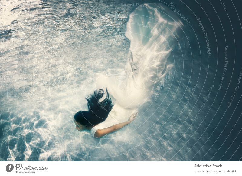 Frau im Brautkleid schwimmt unter Wasser fliegend weiß brünett lange Haare Hochzeit Tiefe genießen Körper Pool Schwimmsport jung romantisch Glück untergetaucht